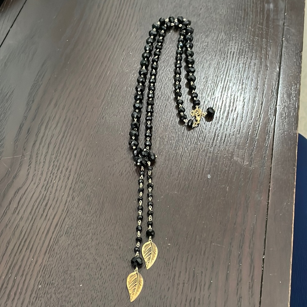 Black and Gold necklace with adjustable length and knot/leaf detail. 14 inches